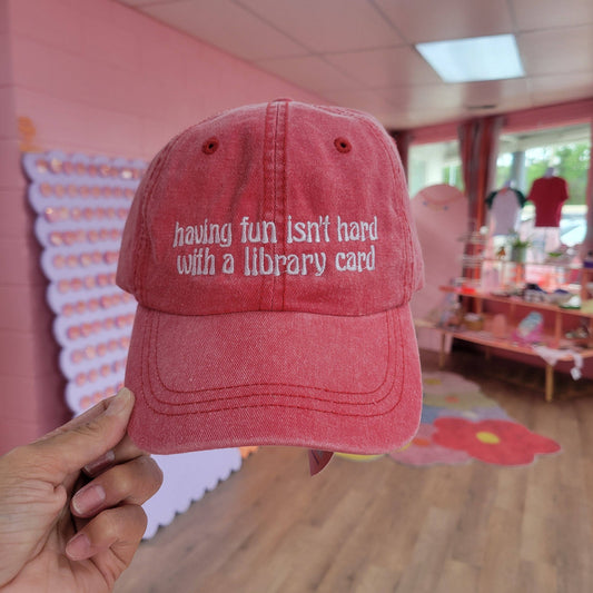 "Having Fun Isn't Hard with a Library Card" Embroidered Hat: Red Wash with White Embroidery